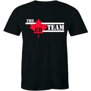 May include: Black t-shirt with a red maple leaf and white text that reads "THE EH TEAM".