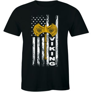 May include: Black t-shirt with a white and gray American flag design. A gold axe with a white handle is centered on the flag. The word "VIKING" is written vertically in white on the right side of the flag.