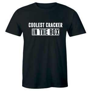 May include: Black t-shirt with white text that reads "Coolest Cracker in the Box".