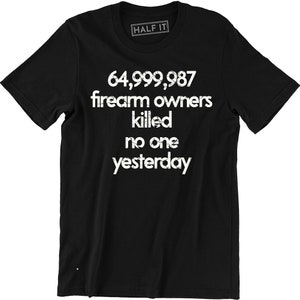 May include: Black t-shirt with white text that reads "64,999,987 firearm owners killed no one yesterday". The text is in a distressed font style. The shirt has a small white tag that reads "HALF IT" on the neckline.
