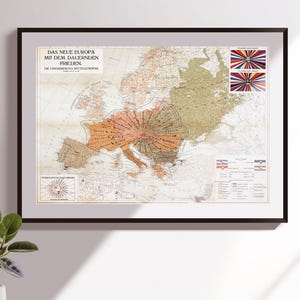 May include: Framed vintage map of Europe with German text. The map shows European countries in different colours, with a central region highlighted. Includes flags and a sunburst design. Measurements are in cm.