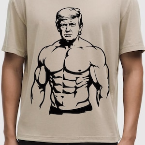 May include: A tan t-shirt featuring a black graphic of a muscular figure with a recognizable hairstyle. The graphic is a stylized illustration of a person with a serious expression.