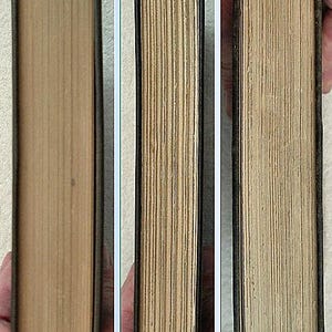May include: Three views of a vintage book, showcasing the aged, cream-colored pages and the dark green binding. The book's spine is visible, with the pages tightly bound. The edges of the pages are slightly uneven, indicating its age.
