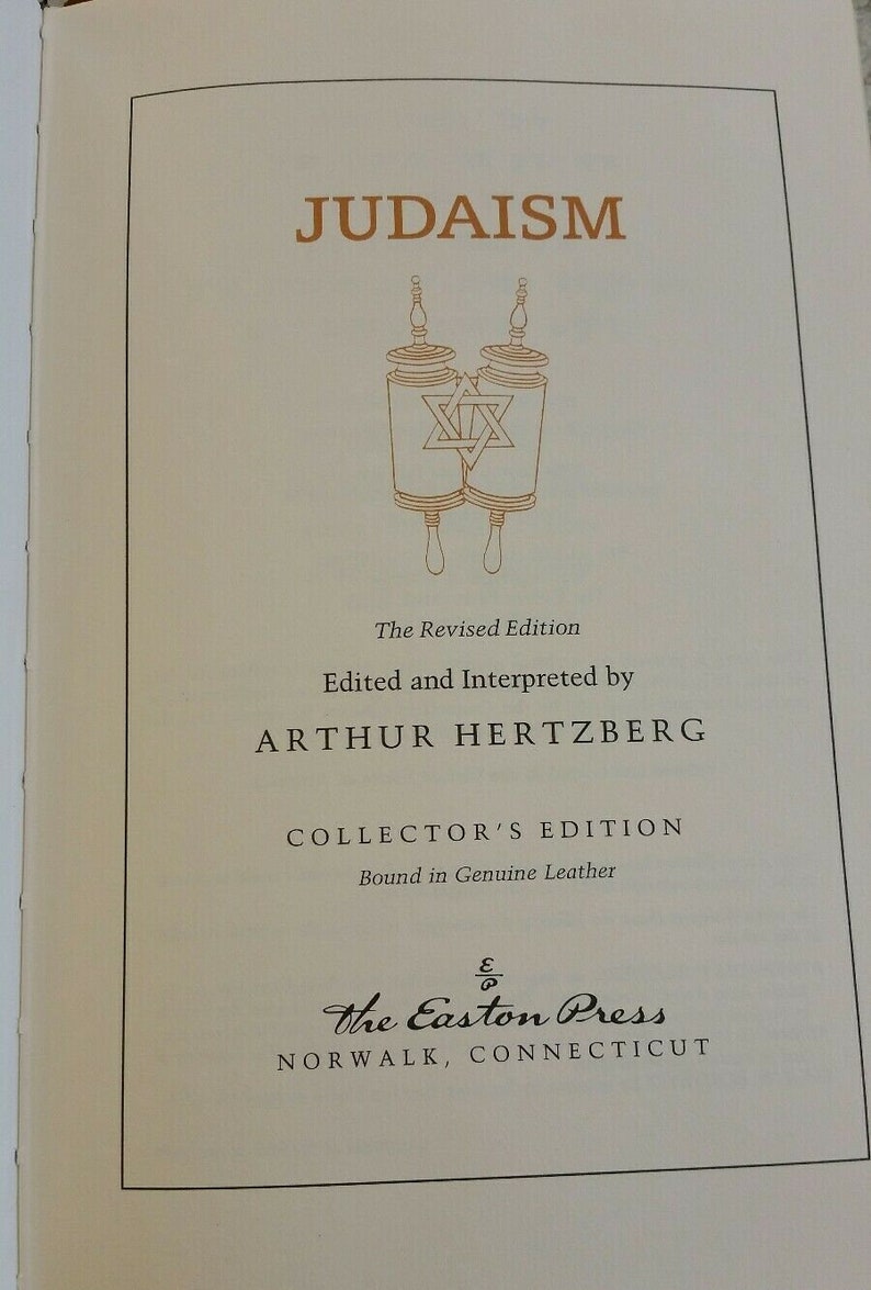 May include: A book titled "JUDAISM" with gold lettering and an illustration of Torah scrolls. The text includes "The Revised Edition," "Edited and Interpreted by ARTHUR HERTZBERG," and "COLLECTOR'S EDITION." The Easton Press, Norwalk, Connecticut is also printed.