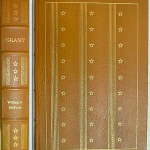 May include: A brown leather-bound book titled "GRANT" with gold star and stripe detailing. The spine features the author's name, William S. McFeely. The cover has a repeating pattern of gold stars and vertical lines.