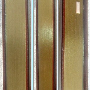 May include: Close-up of the spine of a hardback book with a brown leather cover and gold-colored lettering. The book is closed and the spine is visible.