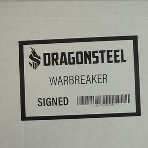 May include: A white box with a black label that says "DragonSteel Warbreaker Signed" with a barcode and a logo of a dragon with an "S" in the middle.