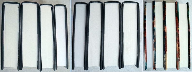 May include: Close-up of six book spines with black covers and white pages. The spines are lined up side-by-side. The first four spines are plain white, while the last two spines have a colourful patterned design.
