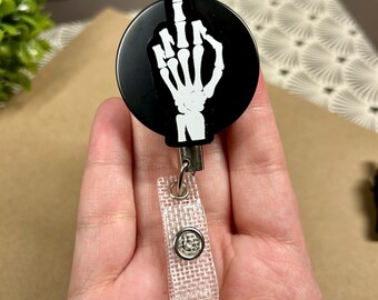 Carrete de insignia resistente con dedo medio esquelético