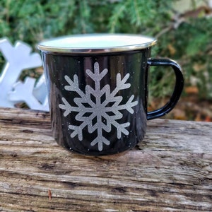 May include: Black enamel mug with a white rim and a silver snowflake design.