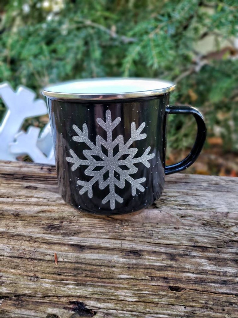 May include: Black enamel mug with a white rim and a silver snowflake design.