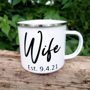 May include: White enamel mug with a black inscription that reads "Wife Est. 9.4.21".