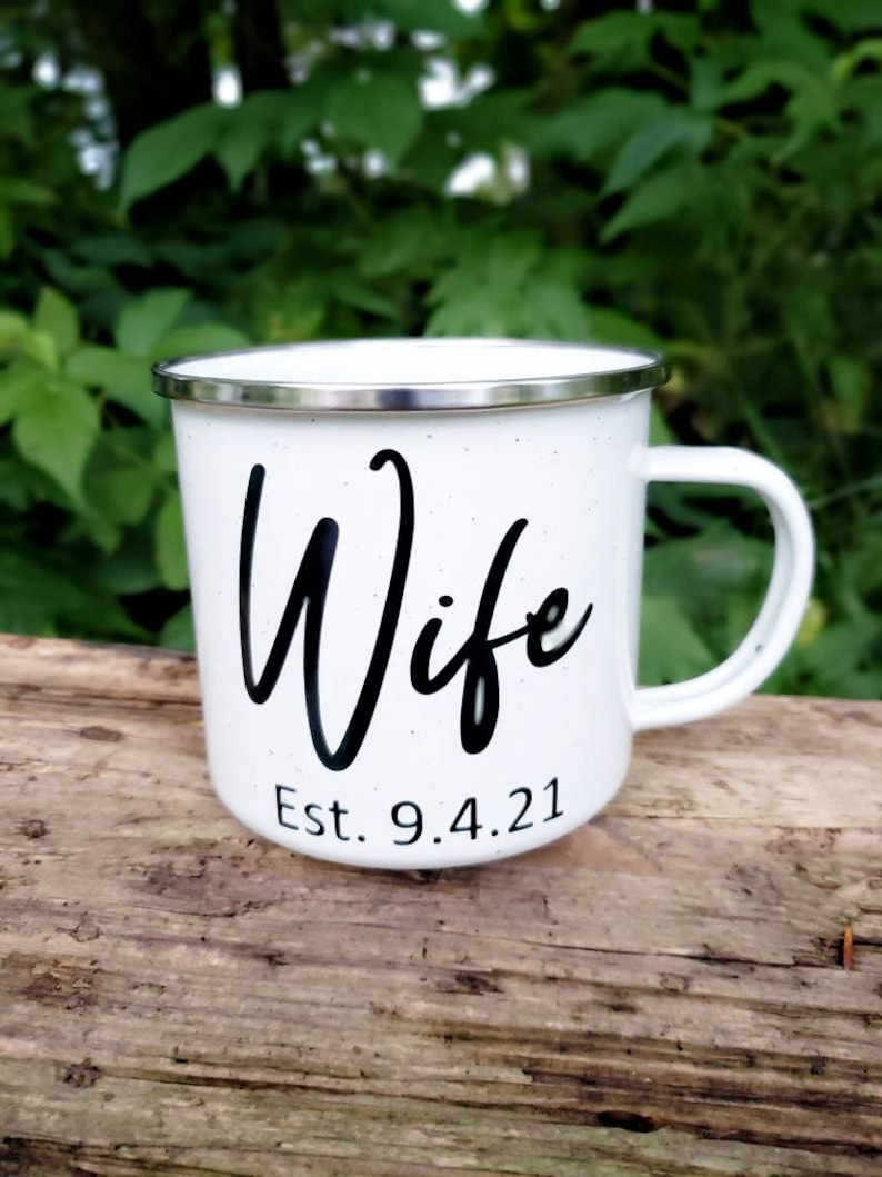 May include: White enamel mug with a black inscription that reads "Wife Est. 9.4.21".