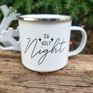 May include: White enamel camping mug with a black design that says "Oh Holy Night" with two stars on either side of the word "Holy".