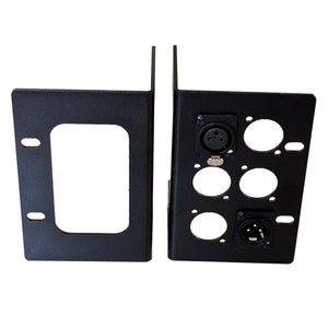 May include: Two black metal brackets. One bracket has a rectangular cutout and two mounting holes. The other bracket has several circular cutouts and two XLR connectors. The brackets are designed for mounting audio equipment.
