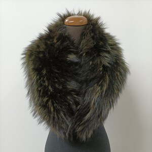 May include: A dark green faux fur collar with a long, fluffy texture. The collar is displayed on a black mannequin.