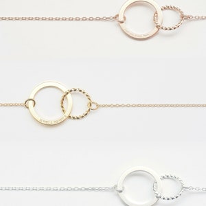 May include: Three gold necklaces with a circle pendant and a smaller circle attached to the larger circle. The larger circle on the top necklace has the inscription "Love you always, Mom". The larger circle on the middle necklace has the inscription "32.7160&deg; S, 153.1619&deg; E".