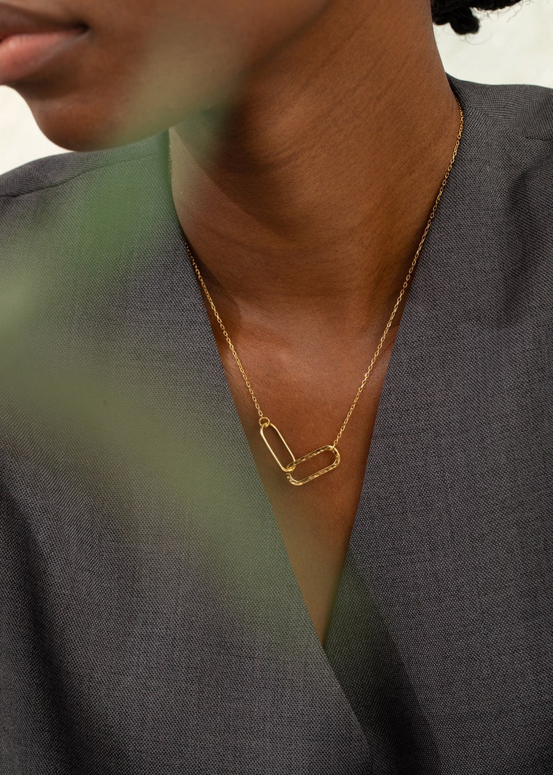 a gold infinity necklace with 2 rectangle linked together which symbolizes the infinity symbol, giving it a standout and distinctive look