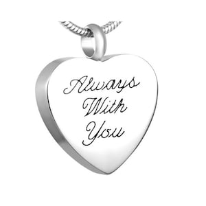 Könnte beinhalten: Silberne Halskette mit herzförmigem Anhänger und Kette. Der Anhänger trägt die eingravierte Aufschrift "Always With You".