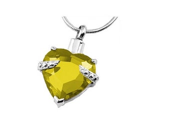 May include: A silver heart-shaped pendant necklace with a large yellow crystal and small clear crystals around the edges.