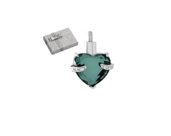 May include: A teal heart-shaped pendant with silver-coloured metal and small, clear stones. A small, silver-coloured box is also present. The pendant is designed to hold a small amount of cremated remains.
