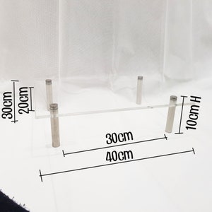 May include: Clear acrylic shelf with four silver metal legs. The shelf is 30 inches long, 40 inches wide, and 10 inches high.