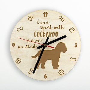 May include: A wooden clock with a brown silhouette of a Cockapoo dog. The clock face reads "Time spent with Cockapoo is never wasted".