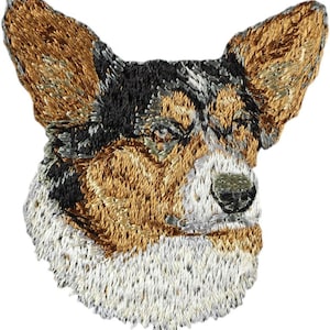 Könnte beinhalten: Gestickter Aufnäher mit dem Kopf eines braunen und schwarzen Cardigan Welsh Corgi Hundes. Der Hund hat weißes Fell auf der Brust und eine schwarze Nase.