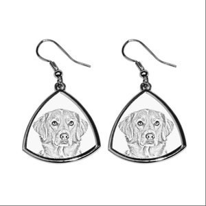 May include: A pair of silver-toned earrings. Each earring features a triangular frame with a detailed black and white sketch of a dog's face. The dog has a focused gaze and a soft, textured coat.