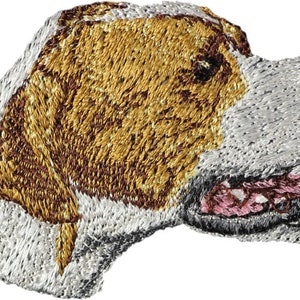Op de afbeelding: Gestikt patch van een witte en bruine hond met een bruine neus en roze tong. De hond kijkt naar rechts en heeft zijn bek open.