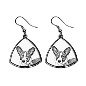 May include: A pair of silver dangle earrings with a black and white image of a Cardigan Welsh Corgi dog on each earring.