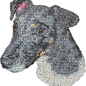 May include: Embroidered patch of a grey and white dog's head. The dog has a black nose and brown eyes.