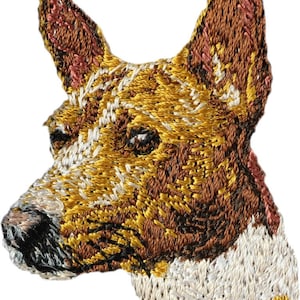 May include: Embroidered patch of a brown and white Basenji dog head with a white background.