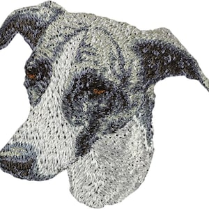 Op de afbeelding: Geborduurd portret van een hondenkop, met een gedetailleerd ontwerp in grijstinten, zwart en wit. De ogen van de hond zijn bruin. Het kunstwerk heeft een getextureerde, gestikte uitstraling, die de kenmerken van de hond benadrukt.