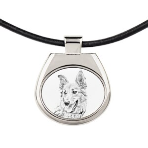 Könnte beinhalten: Eine silberne Halskette mit einem schwarzen Lederband. Der Anhänger zeigt ein rundes Bild eines schwarz-weißen Hundes mit herausgestreckter Zunge.