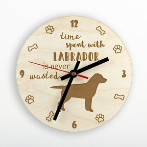 Könnte beinhalten: Eine Holzuhr mit einer braunen Labrador-Silhouette und dem Text "Zeit, die man mit einem Labrador verbringt, ist nie verschwendet". Das Zifferblatt der Uhr hat schwarze Zeiger und römische Ziffern.
