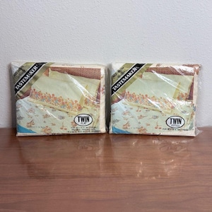Könnte beinhalten: Zwei Packungen Tastemaker No Iron Muslin Bettlaken im Sweet Song Muster. Eine Packung enthält ein flaches Laken für eine 99 mal 191 cm Matratze, die andere ein Spannbettlaken für eine 99 mal 191 cm Matratze, beide mit Blumenmustern.