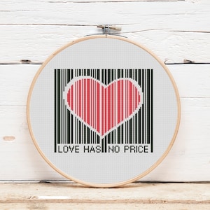 May include: A white embroidery hoop with a black and white barcode design. A red heart is in the center of the barcode. The text "LOVE HAS NO PRICE" is below the barcode.