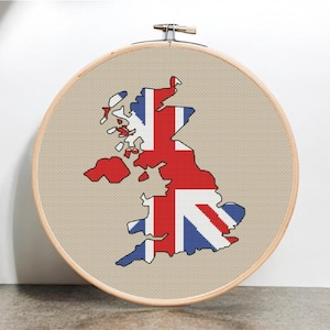 May include: A cross-stitch embroidery hoop with a beige fabric background. The fabric features a cross-stitch design of the United Kingdom map with the Union Jack flag colors.