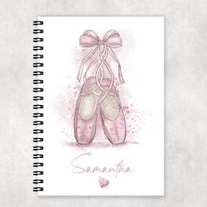 Può includere: Un quaderno a forma di scarpa da ballerina rosa con un fiocco rosa e il nome Samantha sulla copertina.
