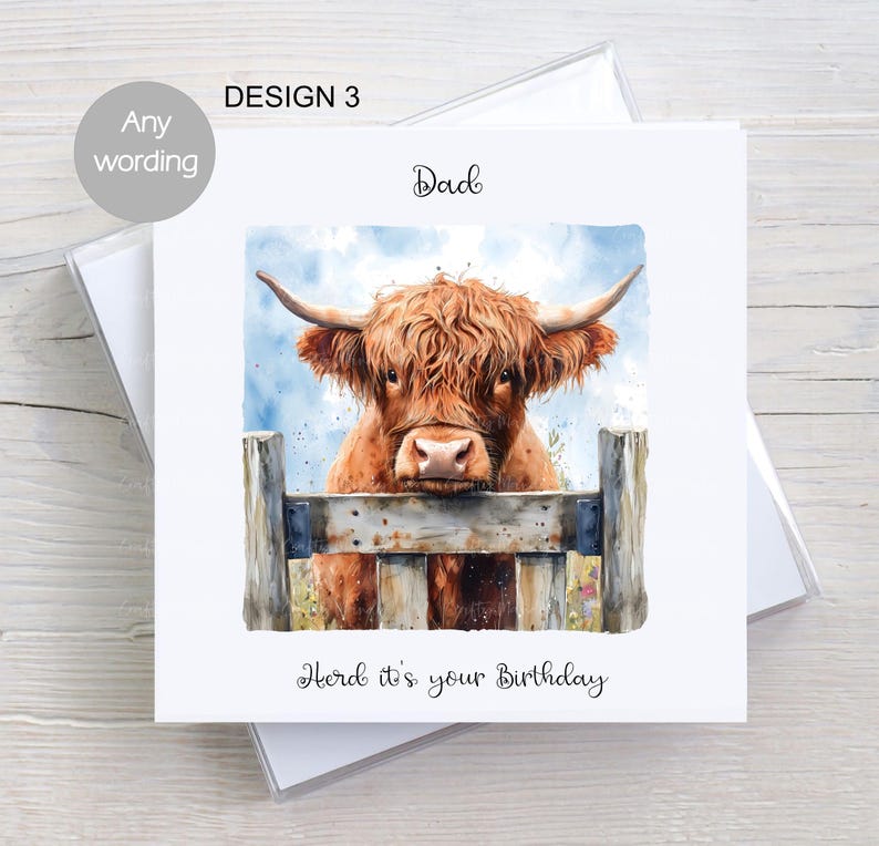 May include: A birthday card featuring a watercolour illustration of a Highland cow peeking over a wooden fence. The card has the text "Dad" and "Heard it's your birthday" on it.