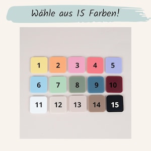 May include: A selection of 15 colorful square tiles, each with a different number from 1 to 15. The tiles are in various colors, including yellow, pink, red, blue, green, and brown. The text "W&auml;hle aus 15 Farben!" is at the top.