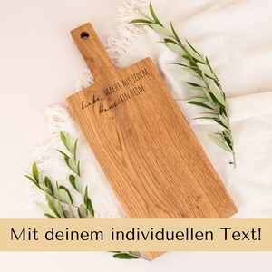 Könnte beinhalten: Ein Holzbrett mit Griff, graviert mit dem Text "Liebe macht aus jedem Haus ein Heim".