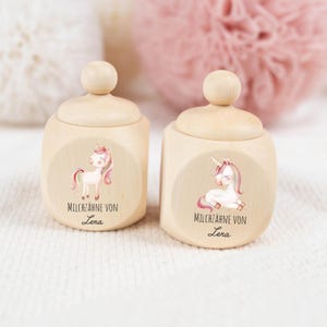 Könnte beinhalten: Zwei Holzkisten mit Deckel, jede mit einer Einhorn-Illustration und dem Text "Milchzähne von Lena".