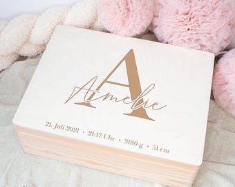 May include: A wooden keepsake box with a light wood finish. The lid is engraved with the letter "A" and the name "Amelie" in a cursive font. The date "21. Juli 2021", time "21:17 Uhr", weight "3180 g", and length "51 cm" are also engraved on the lid.