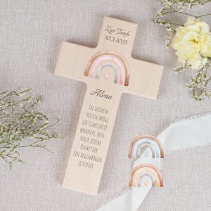 Könnte beinhalten: Ein Holzkreuz mit einem Regenbogen-Design und dem Text "Zur Taufe 30.3.2025 Alena IN DEINEM HERZEN MOGE DIE GEWISSHEIT WOHNEN, DASS NACH JEDEM UNWETTER EIN REGENBOGEN LEUCHTET"