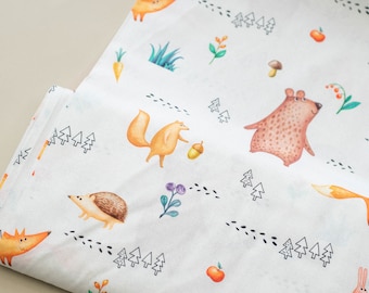 Peut inclure: Tissu blanc avec un motif répété d'animaux de la forêt, notamment des renards, des écureuils, des hérissons et un ours. Les animaux sont illustrés dans un style aquarelle avec des contours noirs. Le tissu présente également de petits arbres noirs, des pommes rouges et des glands bruns.