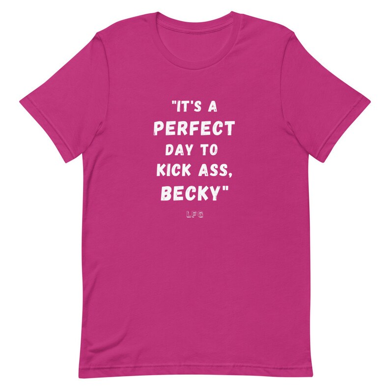 May include: A magenta-colored t-shirt with the phrase "IT'S A PERFECT DAY TO KICK ASS, BECKY" printed in white, along with the initials "LFG" below the text. The shirt has a crew neck and short sleeves.