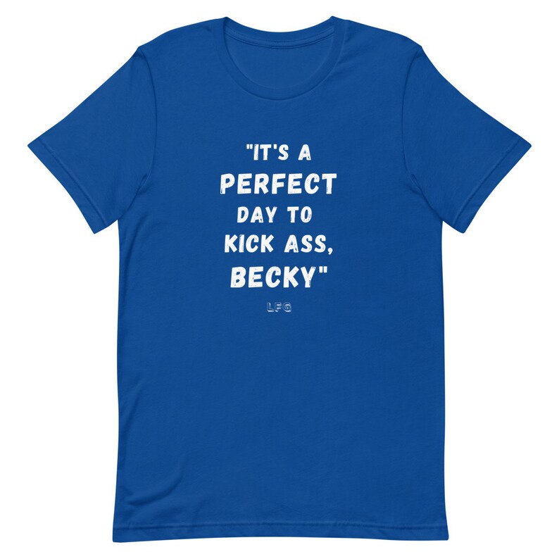 May include: Royal blue t-shirt with the white text: "IT'S A PERFECT DAY TO KICK ASS, BECKY." The initials "LFG" are below the text. The shirt is a short-sleeved crew neck.