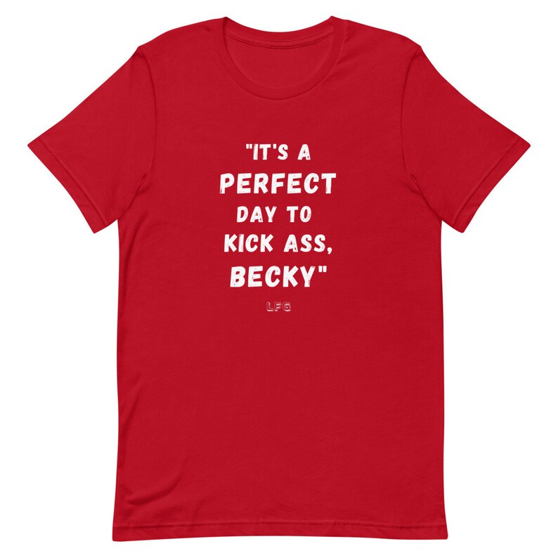 May include: A red t-shirt with white text that reads "IT'S A PERFECT DAY TO KICK ASS, BECKY." The letters "LFG" are below the quote. The shirt has short sleeves and a crew neck.